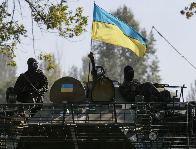Ukrainian servicemen ride in an armoured vehicle near Kramatorsk September 5, 2014. Ukraine and pro-Russian rebels agreed a ceasefire on Friday, the first step towards ending fighting in eastern Ukraine that has caused the worst standoff between Moscow and the West since the Cold War ended. REUTERS/Gleb Garanich (UKRAINE - Tags: POLITICS CIVIL UNREST MILITARY CONFLICT)
